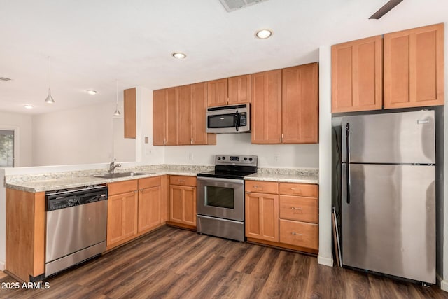 kitchen featuring kitchen peninsula, stainless steel appliances, sink, dark hardwood / wood-style floors, and hanging light fixtures