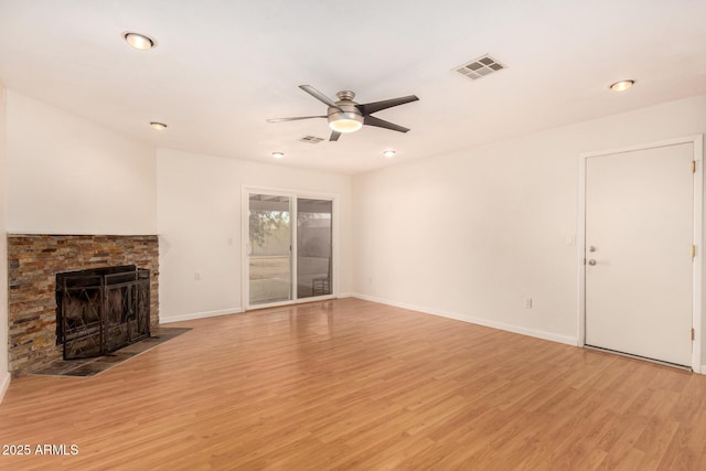 unfurnished living room featuring a fireplace, light wood-type flooring, and ceiling fan