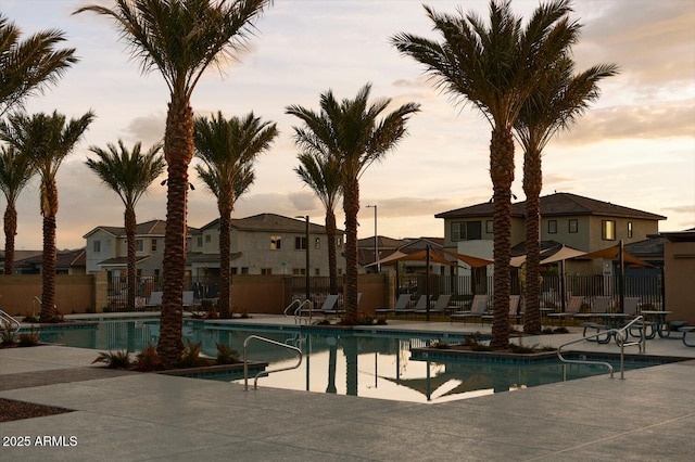 pool at dusk featuring a patio area