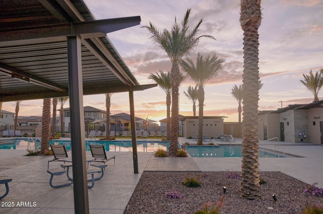 pool at dusk featuring a patio area