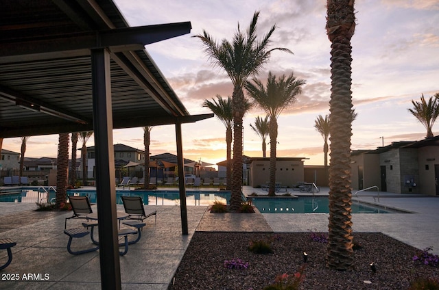 pool at dusk with a patio area