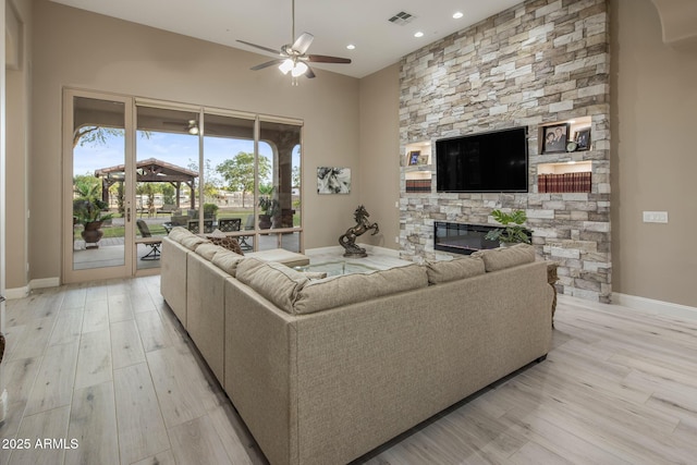 6861 W Calle Lejos, Peoria, AZ 85383 - living room with ceiling fan, a fireplace, light wood finished floors, and recessed lighting