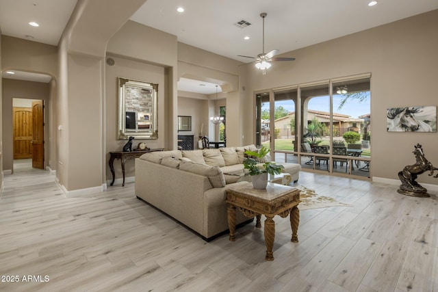 6861 W Calle Lejos, Peoria, AZ 85383 - living room featuring arched walkways, a ceiling fan, light wood finished floors, and recessed lighting