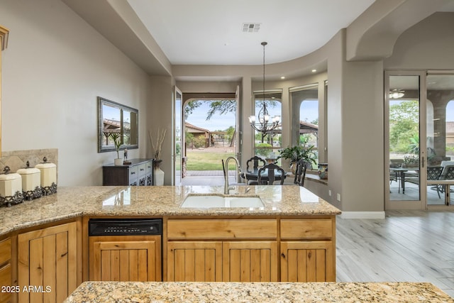 6861 W Calle Lejos, Peoria, AZ 85383 - kitchen featuring dishwasher, a chandelier, light stone countertops, light wood finished floors, and pendant lighting