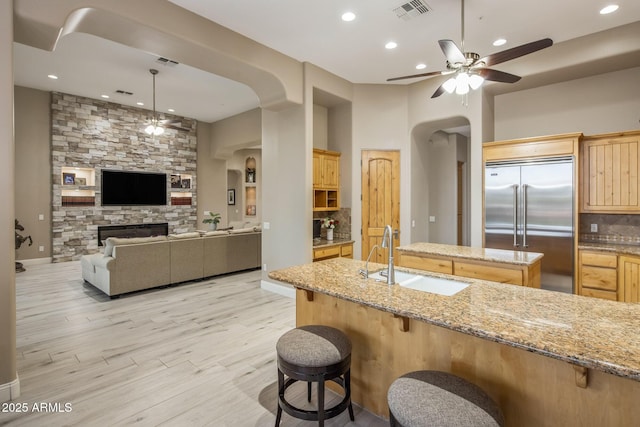 6861 W Calle Lejos, Peoria, AZ 85383 - kitchen with built in refrigerator, arched walkways, a ceiling fan, light brown cabinetry, and backsplash