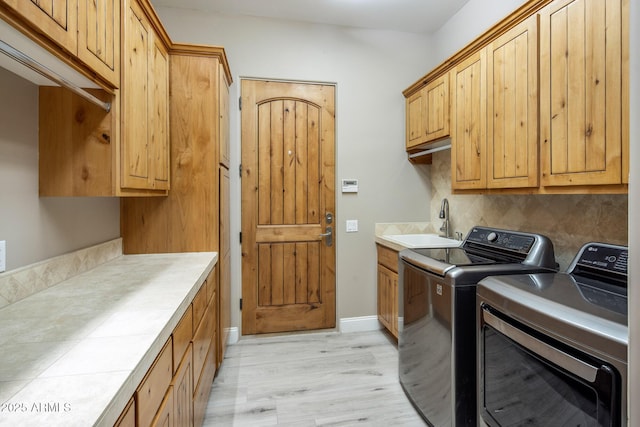 6861 W Calle Lejos, Peoria, AZ 85383 - washroom with independent washer and dryer, cabinet space, and light wood-style flooring