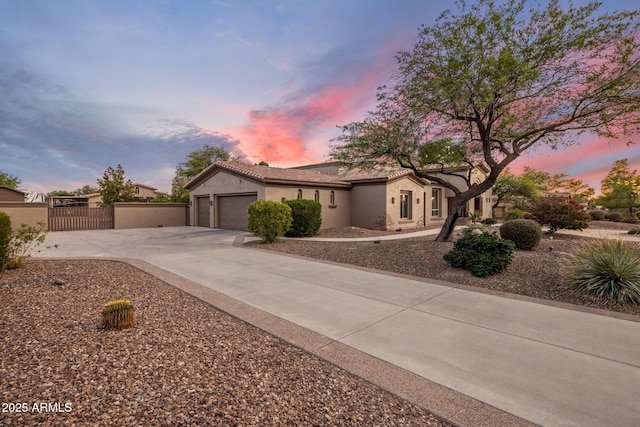 6861 W Calle Lejos, Peoria, AZ 85383 - view of front facade featuring concrete driveway, an attached garage, stucco siding, and a gate