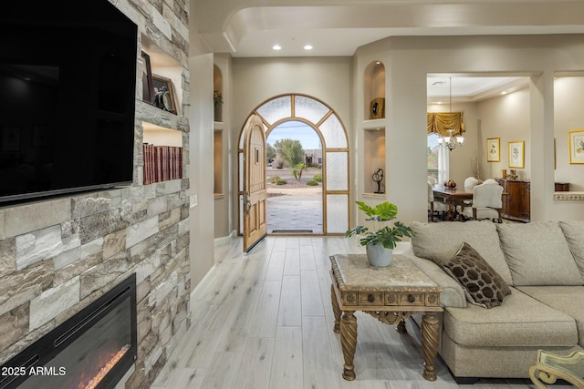 6861 W Calle Lejos, Peoria, AZ 85383 - living room featuring a chandelier, light wood finished floors, recessed lighting, and a glass covered fireplace