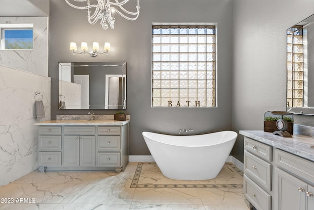 bathroom featuring vanity, a chandelier, and a bath