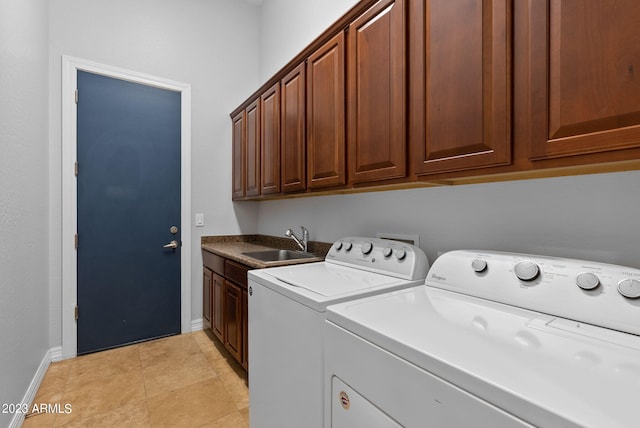 clothes washing area with cabinets, washing machine and dryer, light tile patterned flooring, and sink