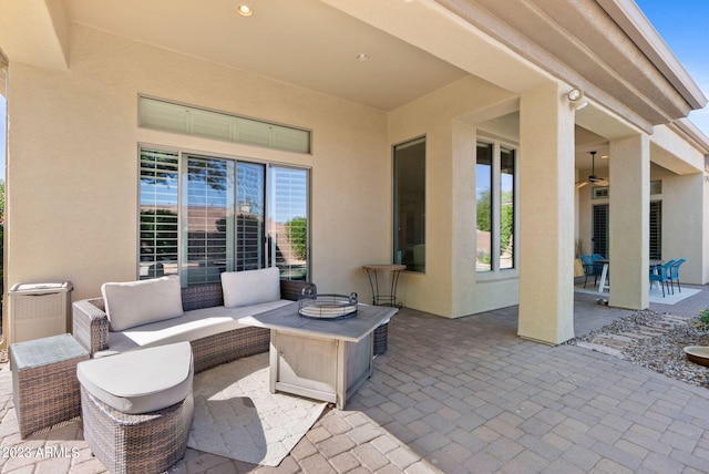 view of patio with an outdoor living space with a fire pit and ceiling fan