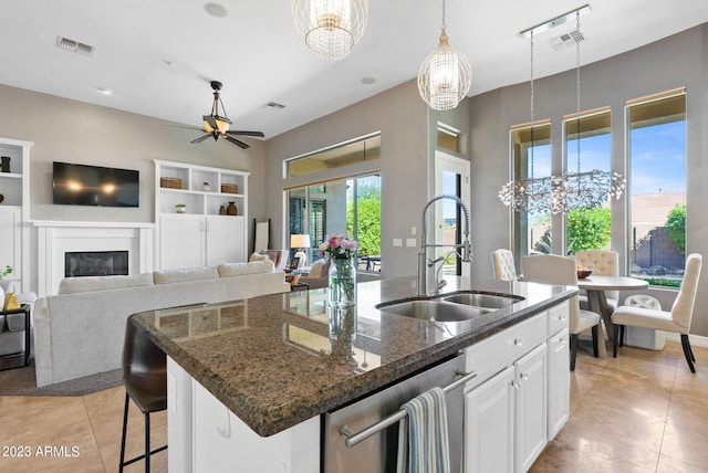 kitchen with a center island with sink, dishwasher, sink, and white cabinets