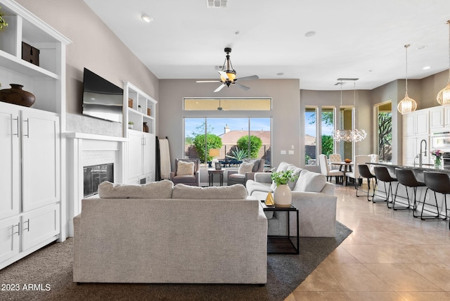 tiled living room featuring sink, ceiling fan, and plenty of natural light