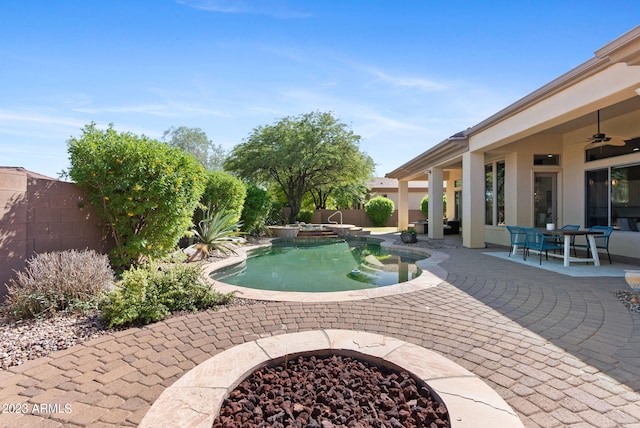 view of swimming pool with a patio, ceiling fan, and a fire pit