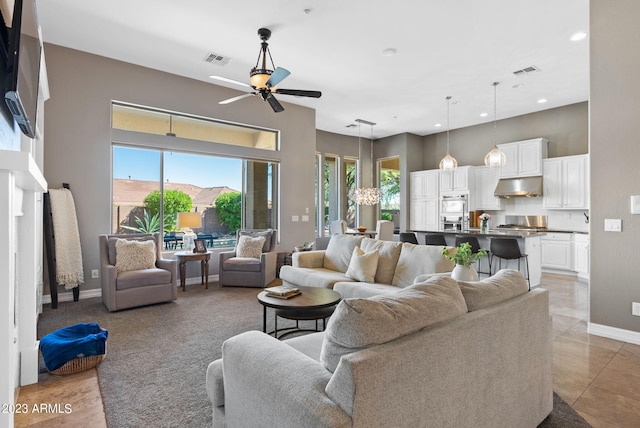 living room featuring ceiling fan, plenty of natural light, and light tile patterned floors