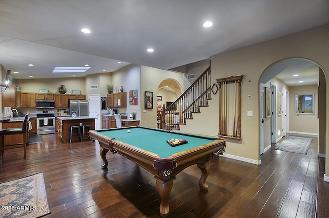 rec room with arched walkways, pool table, and dark wood-style floors