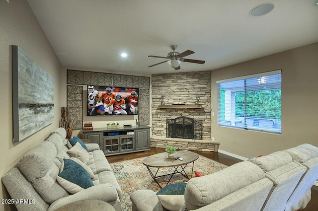 living area featuring baseboards, a fireplace, ceiling fan, and wood finished floors