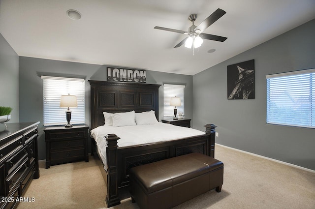 bedroom with lofted ceiling, multiple windows, light carpet, and baseboards
