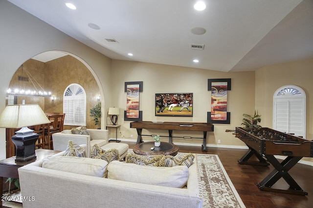living room with wood finished floors, visible vents, and vaulted ceiling
