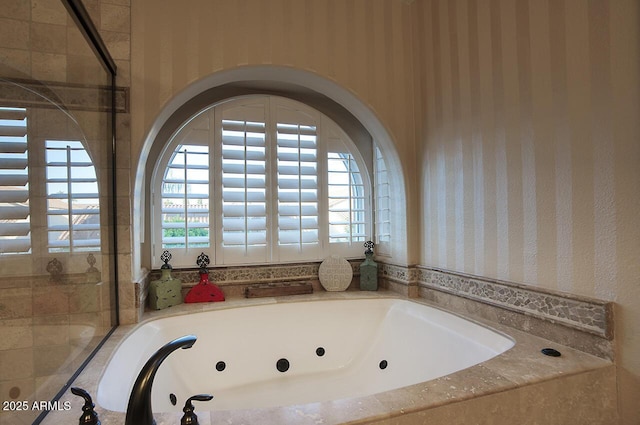 full bathroom with a tub with jets and wallpapered walls