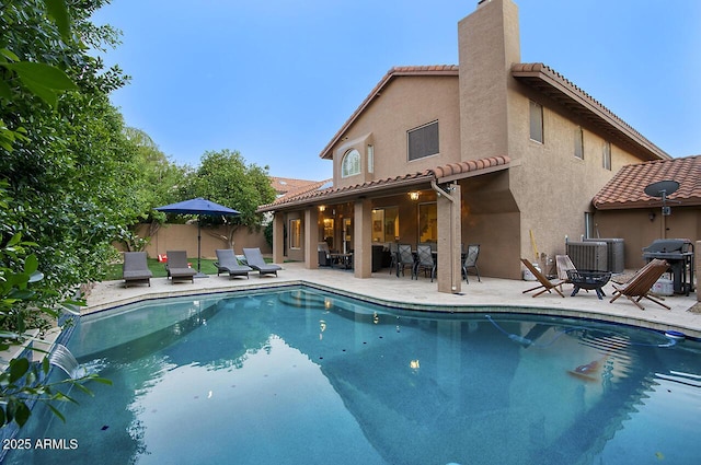 view of pool with a patio, central AC, fence, grilling area, and a fenced in pool