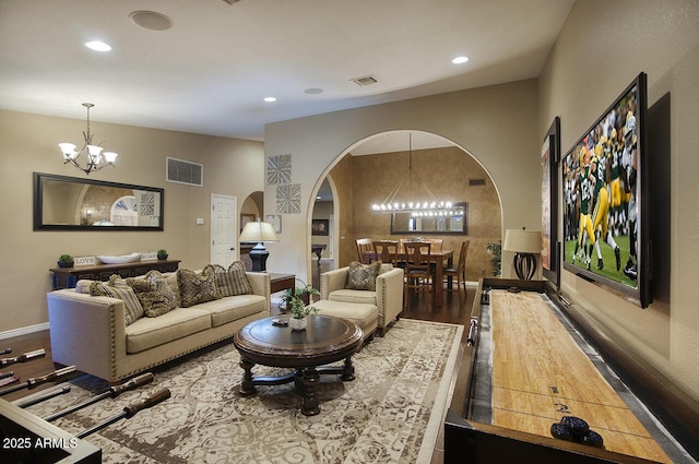 living room with wood finished floors, visible vents, recessed lighting, a chandelier, and arched walkways