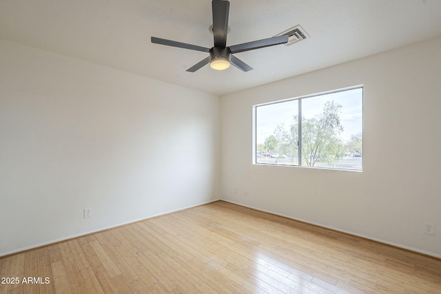 spare room featuring visible vents, ceiling fan, and wood-type flooring