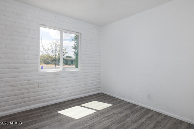 unfurnished room with baseboards and dark wood-style floors