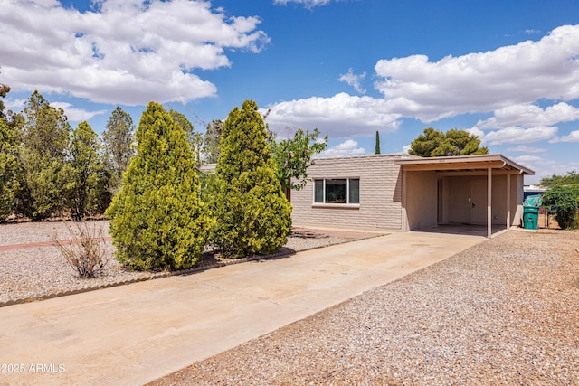 view of front of house featuring a carport, brick siding, and driveway