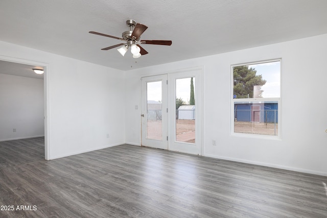 spare room featuring baseboards, a ceiling fan, and wood finished floors