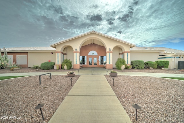 mediterranean / spanish-style home with central air condition unit and french doors