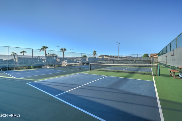 view of tennis court with basketball hoop