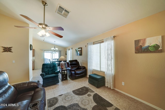 tiled living room with ceiling fan with notable chandelier, a healthy amount of sunlight, and vaulted ceiling