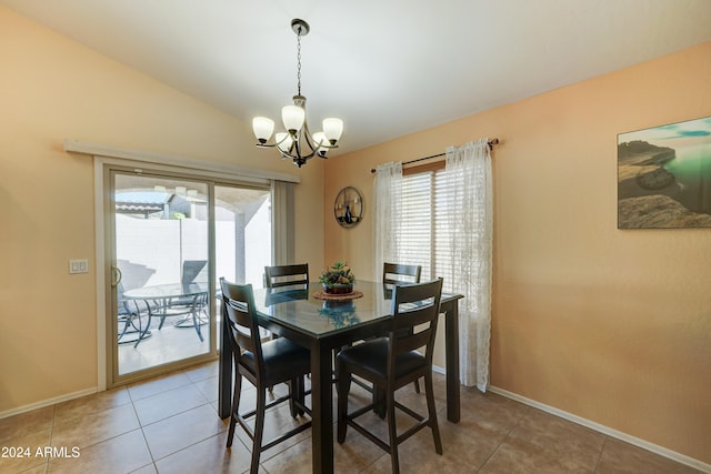 dining area featuring tile patterned flooring, lofted ceiling, and a chandelier