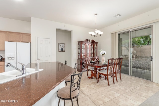 dining room featuring a chandelier, light tile patterned floors, and visible vents