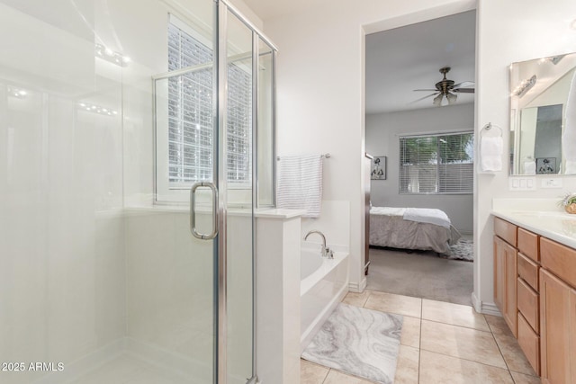 ensuite bathroom featuring vanity, tile patterned flooring, a ceiling fan, a shower stall, and a garden tub
