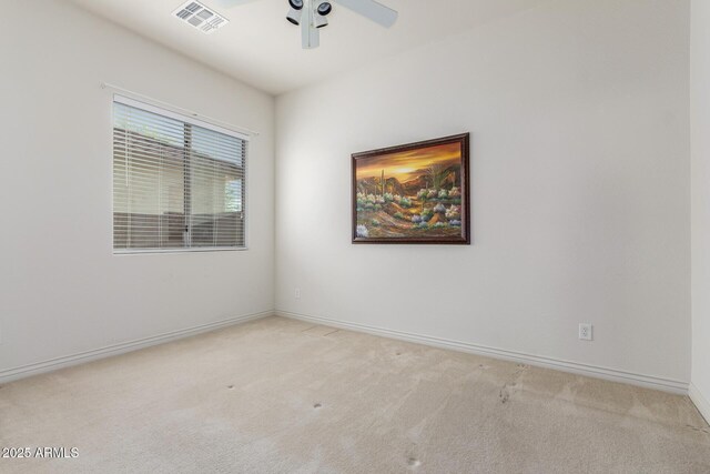 carpeted spare room featuring baseboards, a ceiling fan, and visible vents
