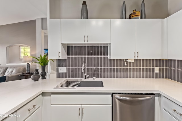 kitchen featuring light countertops, tasteful backsplash, stainless steel dishwasher, and a sink