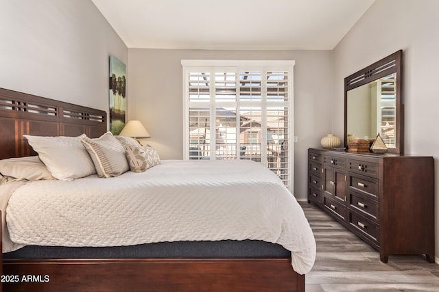 bedroom featuring access to outside and wood finished floors
