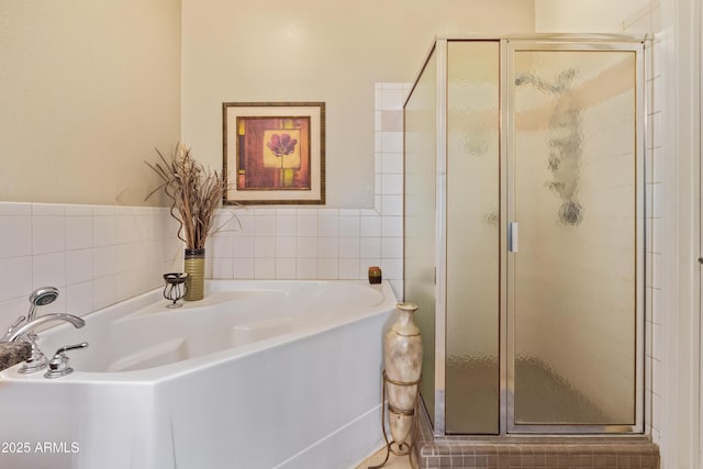 full bath featuring a bath, a stall shower, and tile walls