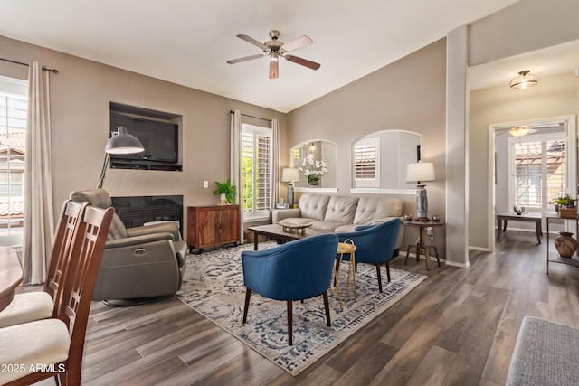 living area with wood finished floors, baseboards, and a ceiling fan