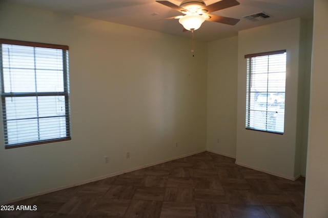 spare room featuring ceiling fan and dark parquet flooring