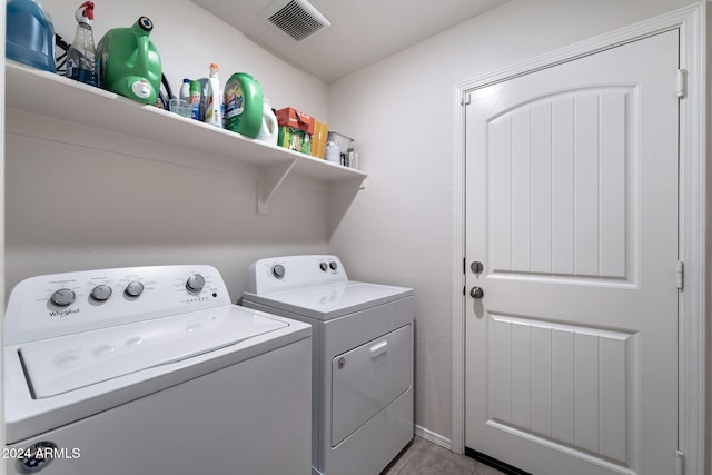 laundry area with washer and dryer and light tile patterned floors