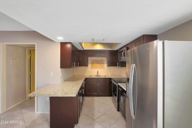 kitchen with sink, light tile patterned floors, a breakfast bar area, stainless steel appliances, and light stone counters