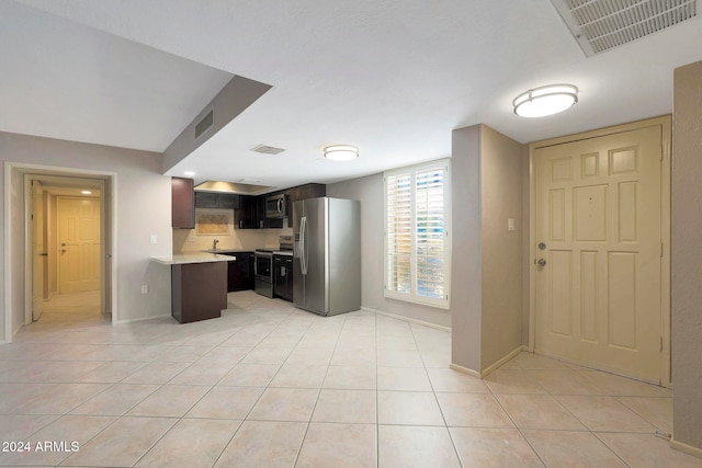 kitchen with appliances with stainless steel finishes, light tile patterned flooring, and dark brown cabinetry