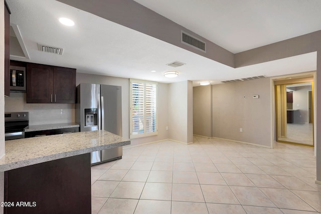 kitchen featuring dark brown cabinets, light tile patterned floors, and appliances with stainless steel finishes