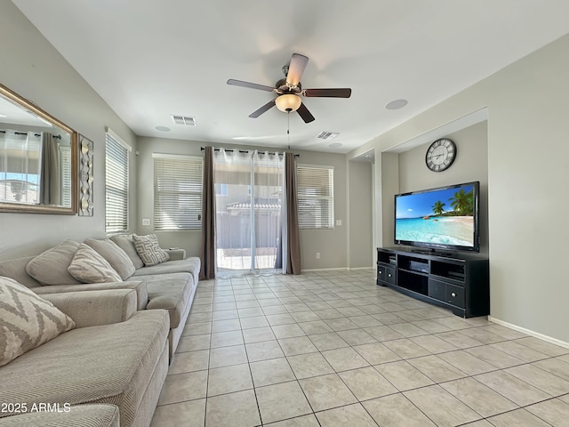 living room featuring light tile patterned floors, visible vents, baseboards, and ceiling fan