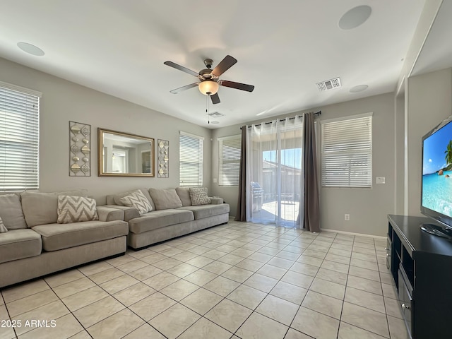 living area with light tile patterned floors, visible vents, baseboards, and ceiling fan