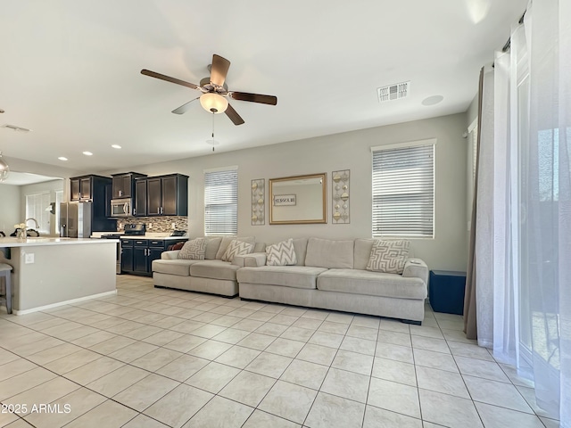 living area featuring light tile patterned floors, visible vents, recessed lighting, and a ceiling fan