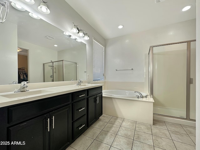 bathroom featuring a shower stall, a garden tub, double vanity, tile patterned floors, and a sink